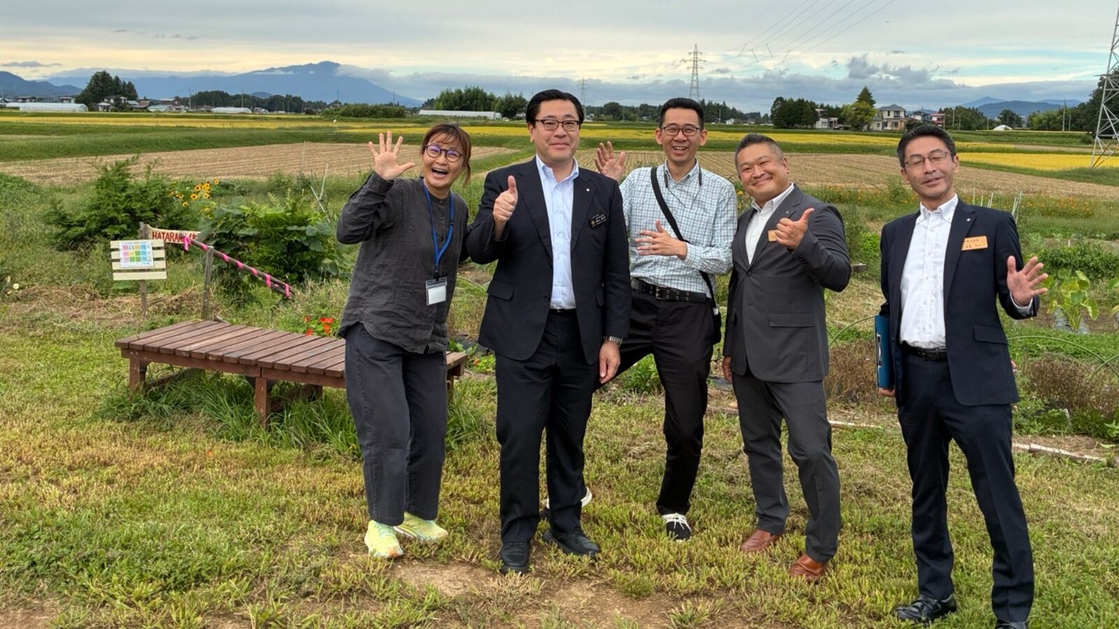くらしの研究室の畑で、岩手県副知事・県庁の皆さんとまどかさんが並んで笑顔で写る集合写真
